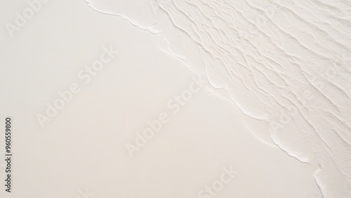 top view of waves on the edge of a white sand beach with texture as a background.