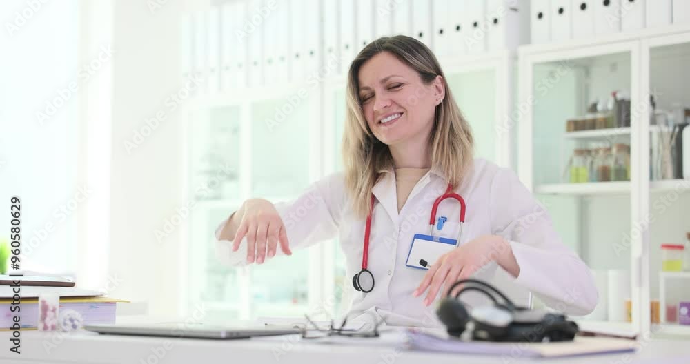 Happy woman doctor closes laptop leaning on chair in clinic. Female medic with stethoscope stretches feeling satisfaction with end of work Happy woman doctor closes laptop leaning on chair in clinic. Female medic with stethoscope stretches feeling satisfaction with end of work