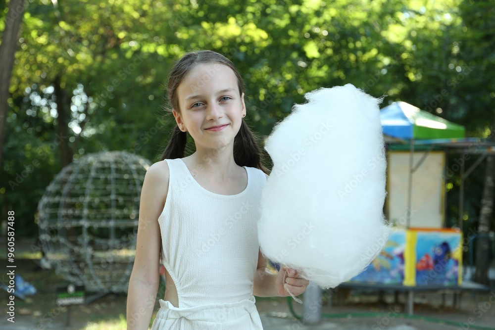 Portrait of little girl with sweet cotton candy in park Portrait of little girl with sweet cotton candy in park