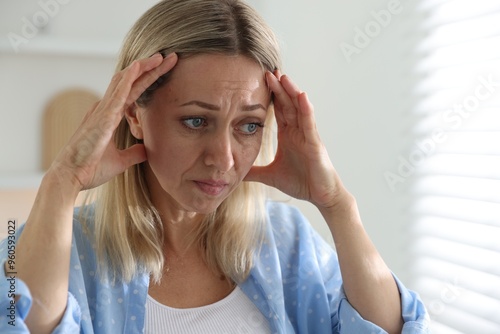 Menopause. Woman suffering from headache at home