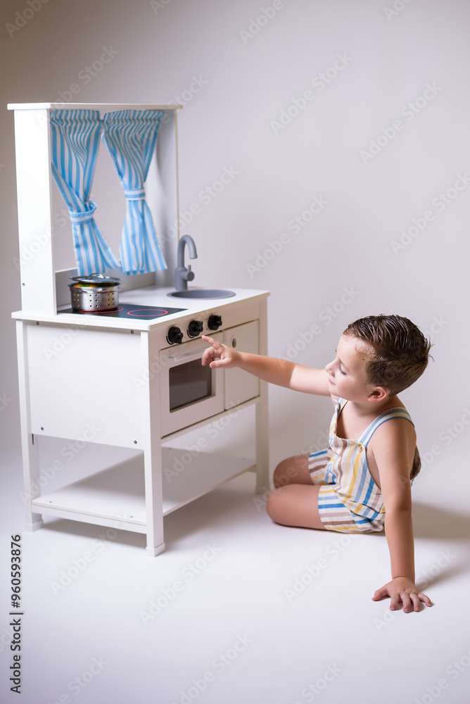 Child plays at cooking in playroom with wooden toys. Symbolic play, cognitive development Child plays at cooking in playroom with wooden toys. Symbolic play, cognitive development