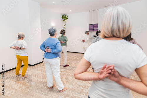 A group of older women are practicing yoga together