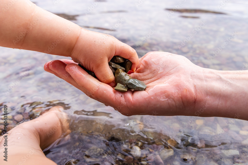 Parent and Child Collecting Pebbles in Scenic Waterton, Alberta, Canada Parent and Child Collecting Pebbles in Scenic Waterton, Alberta, Canada