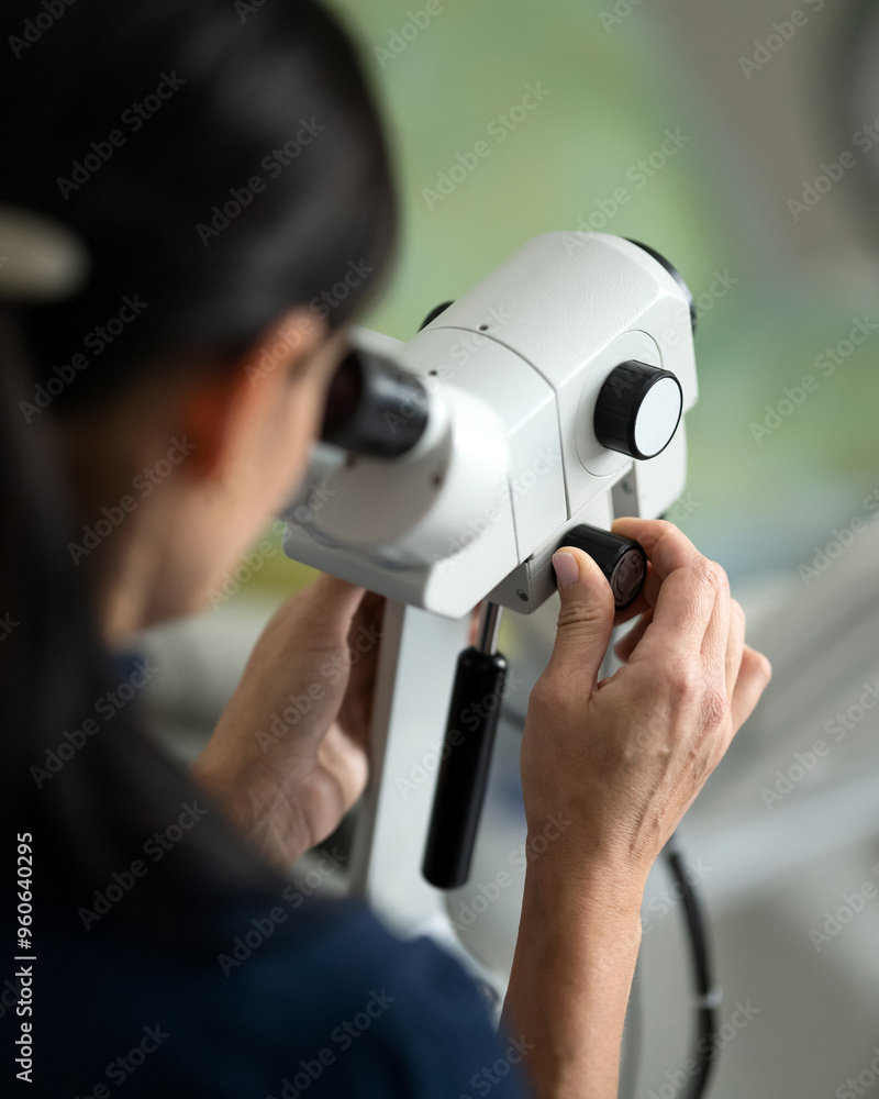 Colposcopy of cervix. Woman doctor works with microscope in gynecological clinic. Gynecologist working with microscope in clinic. Urology. Endocrinology. Video colposcopy. Back view. Soft focus. Colposcopy of cervix. Woman doctor works with microscope in gynecological clinic. Gynecologist working with microscope in clinic. Urology. Endocrinology. Video colposcopy. Back view. Soft focus.