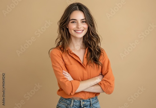 happy, smiling young woman standing with her arms crossed, looking at the camera