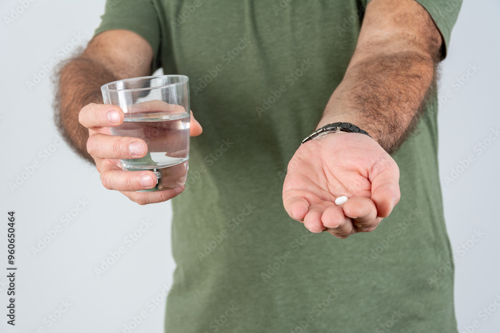 Fototapeta premium Close up of senior man taking medicines with water