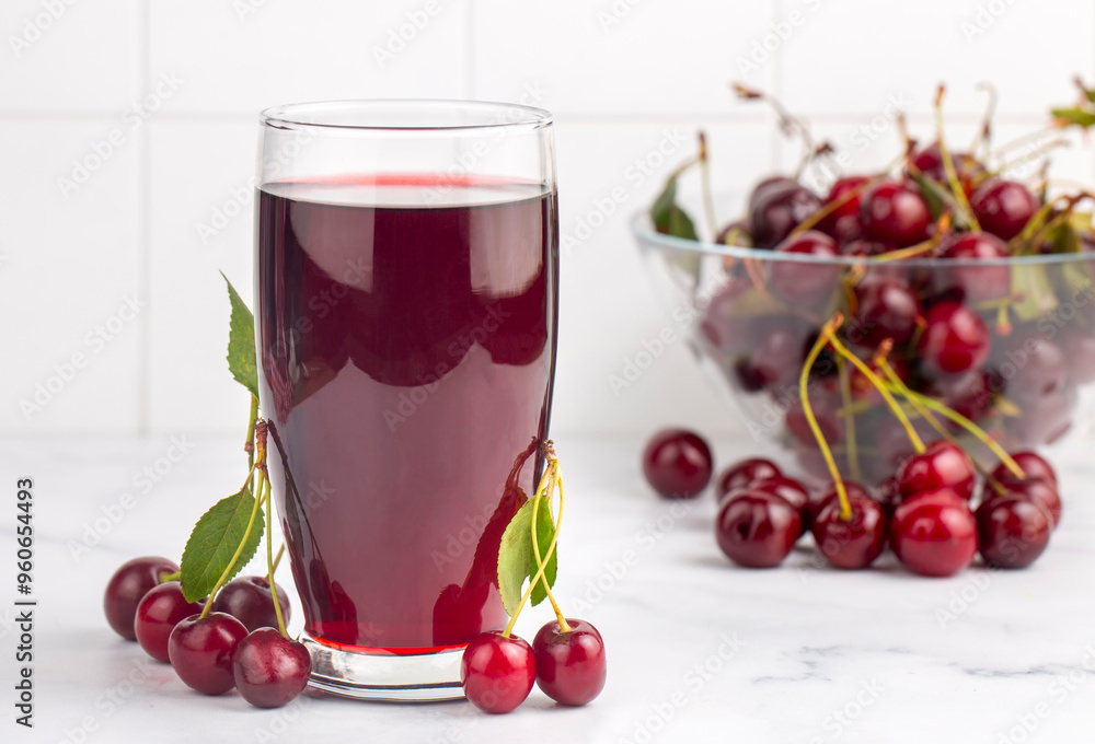 Glass of sour cherry juice with fresh red cherries, summer juice