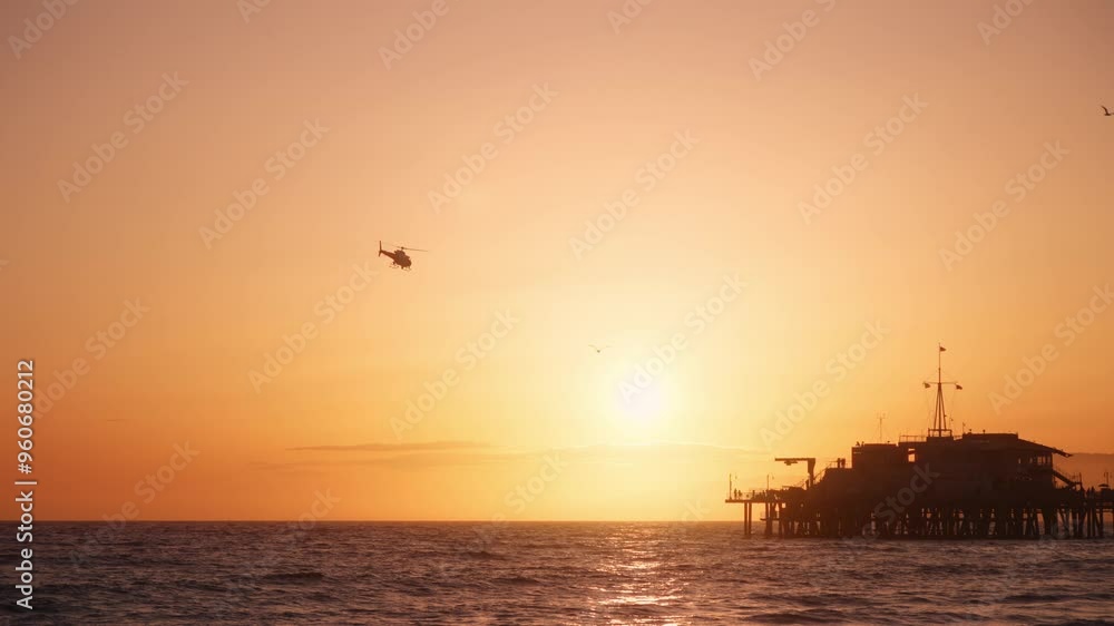 LAPD helicopter flying over Santa Monica pier during a scenic sunset in Los Angeles, California, USA LAPD helicopter flying over Santa Monica pier during a scenic sunset in Los Angeles, California, USA
