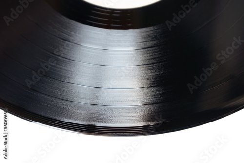 Close-up view of a vinyl record highlighting its glossy surface and unique grooves. Isolated