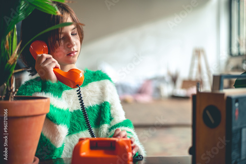 Fotografie retro, cute girl teen talking on old orange vintage phone with dialer