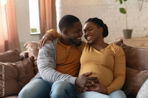 Joyful African American couple cherish moments as they anticipate their first baby while relaxing on a cozy sofa at home