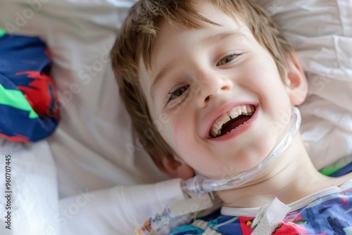Bright smile of a young boy with a tracheostomy tube in a cozy hospital bed during a sunny afternoon