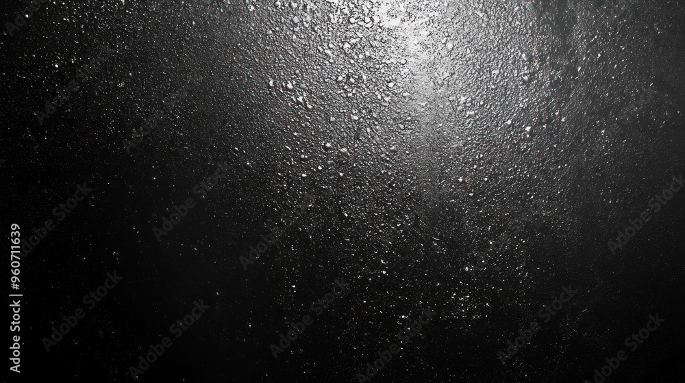 Obraz premium Close-up of water droplets on a dark surface, creating a dramatic and textured visual effect.