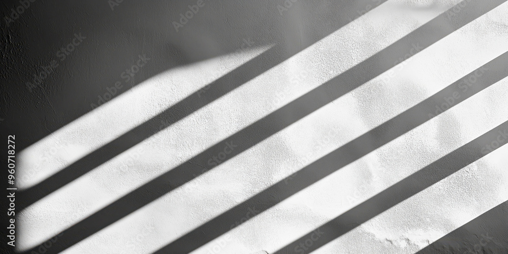 Obraz premium Sunlight casting shadows on textured wall creating geometric patterns
