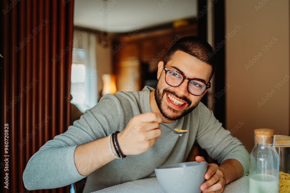 Young caucasian man eating corn flakes for breakfast at home Young caucasian man eating corn flakes for breakfast at home