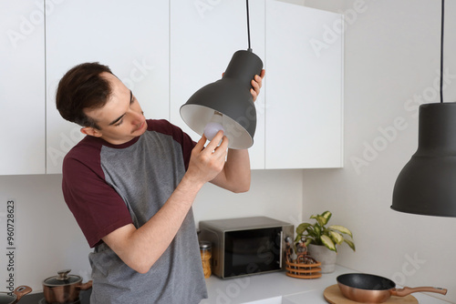 Young man changing light bu...
