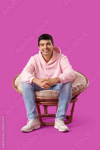Young man sitting in armcha...