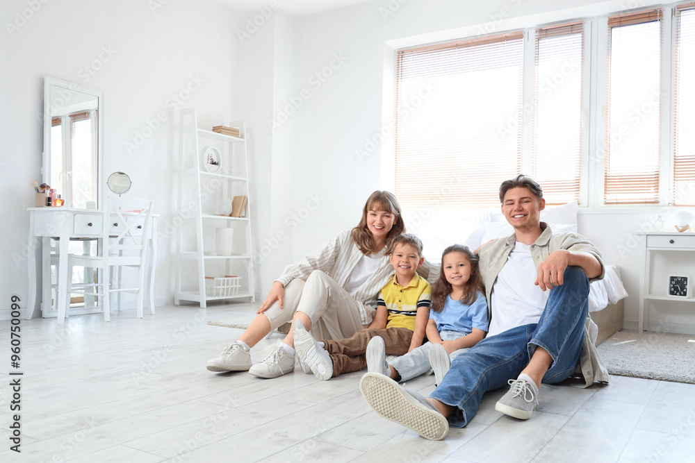 Happy parents with their little children sitting in bedroom Happy parents with their little children sitting in bedroom