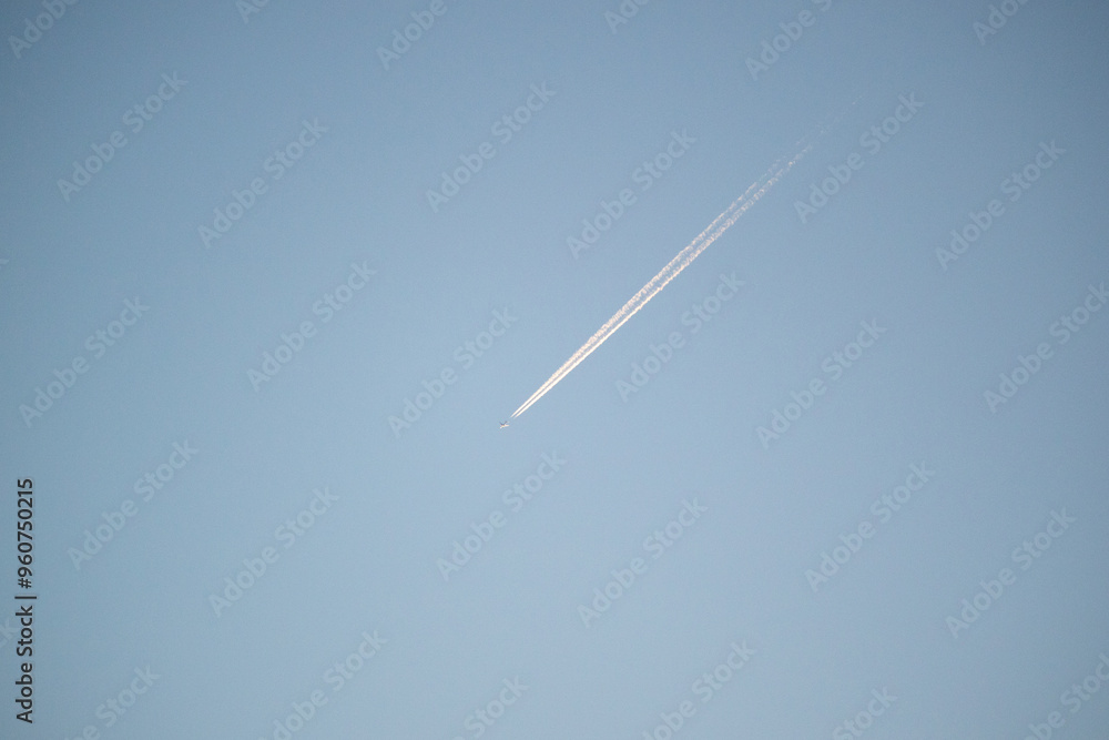 Contrail / chemtrail behind a plane high in sky Contrail / chemtrail behind a plane high in sky