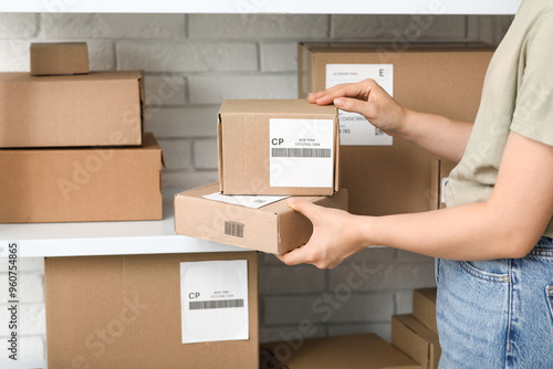 Woman with parcel boxes at postal warehouse, closeup