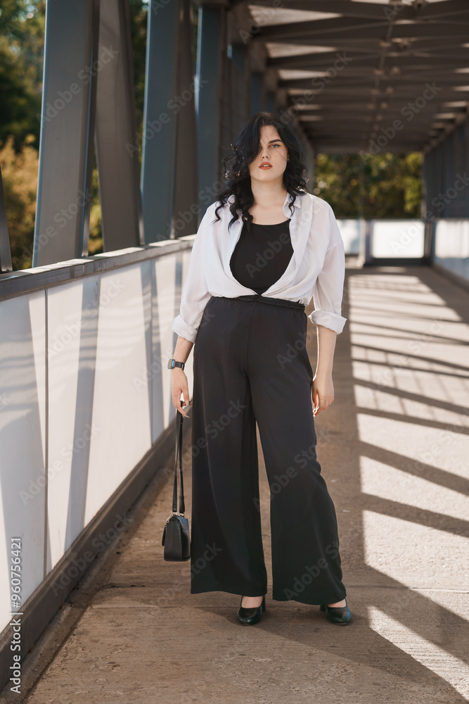 Confident Woman in Chic Black and White Attire on Urban Bridge Confident Woman in Chic Black and White Attire on Urban Bridge