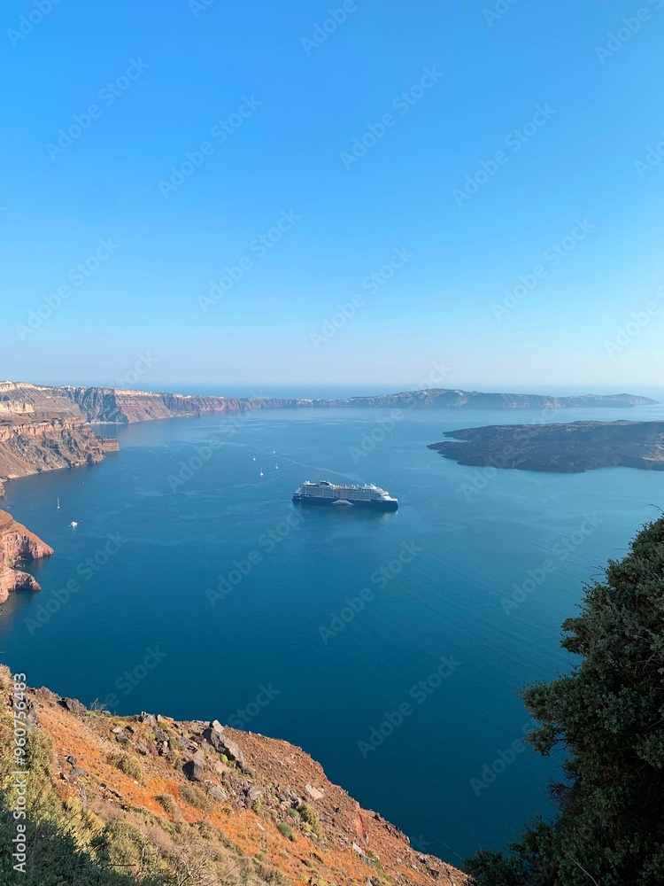 Beautiful view of a boat cruising on the aegean sea and the coastline of Santorini Greece Beautiful view of a boat cruising on the aegean sea and the coastline of Santorini Greece