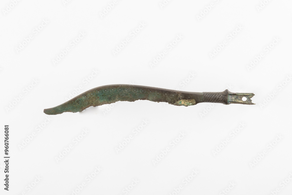 Ancient Bronze Tool Fragment with Engraved Spiral Patterns Isolated on White Background Ancient Bronze Tool Fragment with Engraved Spiral Patterns Isolated on White Background