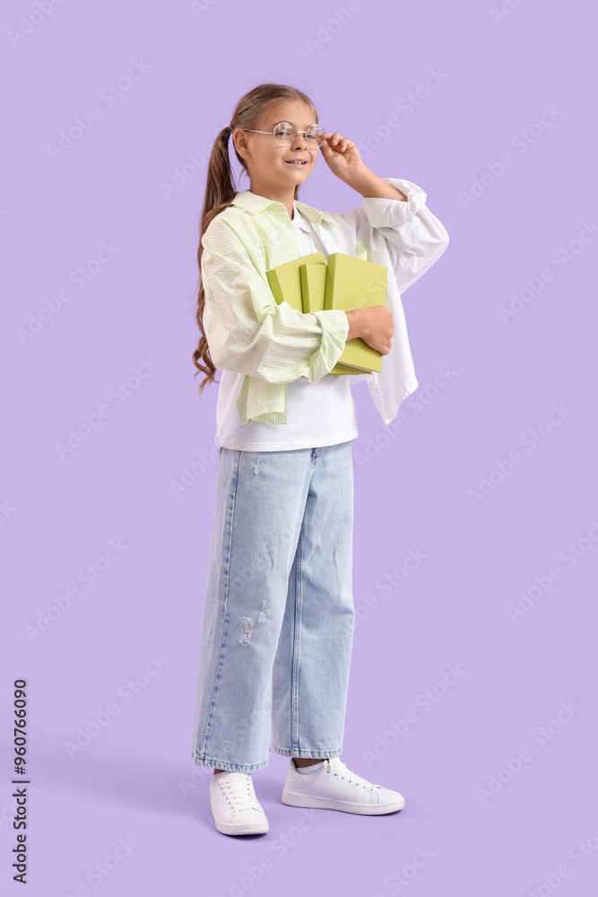 Cute schoolgirl with books on lilac background Cute schoolgirl with books on lilac background