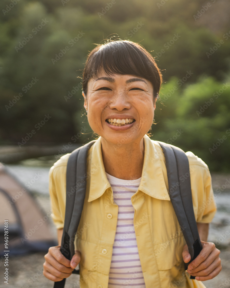 Portrait of mature japanese woman stand in front a tent by the river Portrait of mature japanese woman stand in front a tent by the river