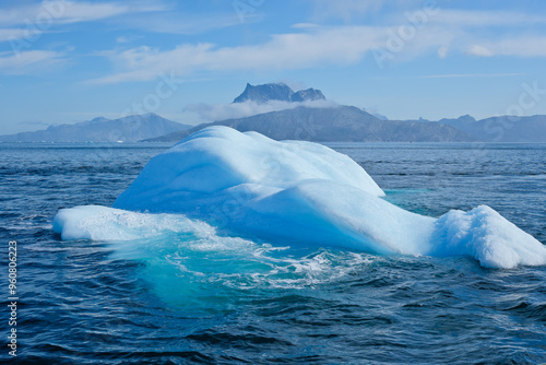 Iceberg in the sea with the background of Sermitsiaq mountain Nuuk Greenland photo