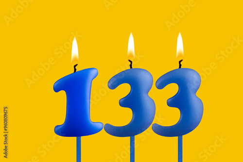 Blue candle number 133 - Birthday on yellow background