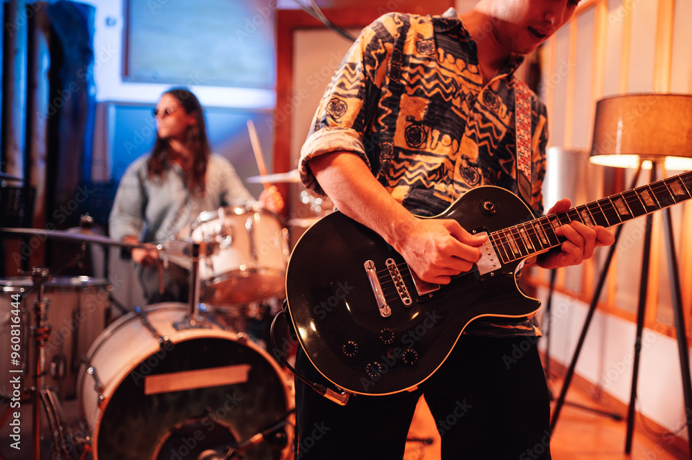 Fototapeta premium Guitar player playing while recording or practicing in a recording studio