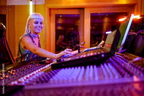 Konstfotografi Blonde woman sound engineer working at the soundboard in her music studio