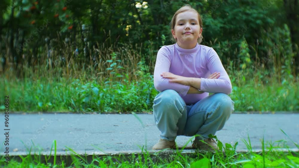 Young girl smiling and posing while crouching on a path in a vibrant park. Surrounded by greenery, she captures the essence of joyful and carefree childhood moments in a peaceful outdoor scene Young girl smiling and posing while crouching on a path in a vibrant park. Surrounded by greenery, she captures the essence of joyful and carefree childhood moments in a peaceful outdoor scene