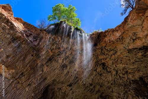 Fotografia The view looking up as water cascades off of the travertine natural bridge at Tonto Natural Bridge State Park near Payson, Arizona