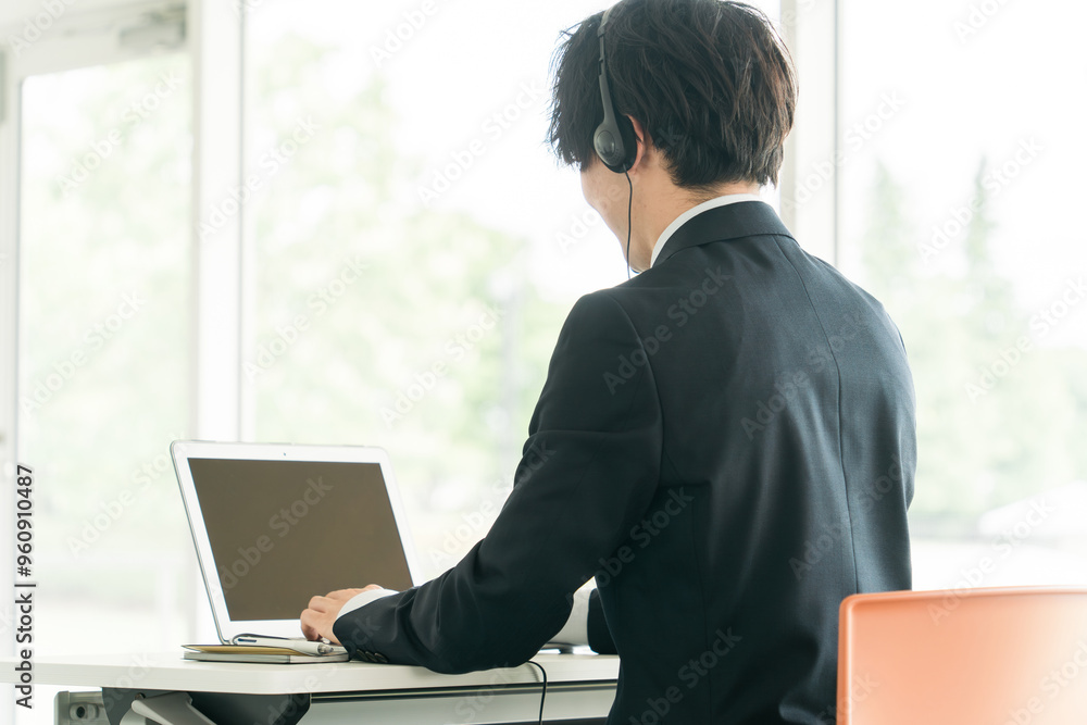 ヘッドセットをつけてパソコンを使う男性
ヘッドセットをつけてパソコンを使う男性