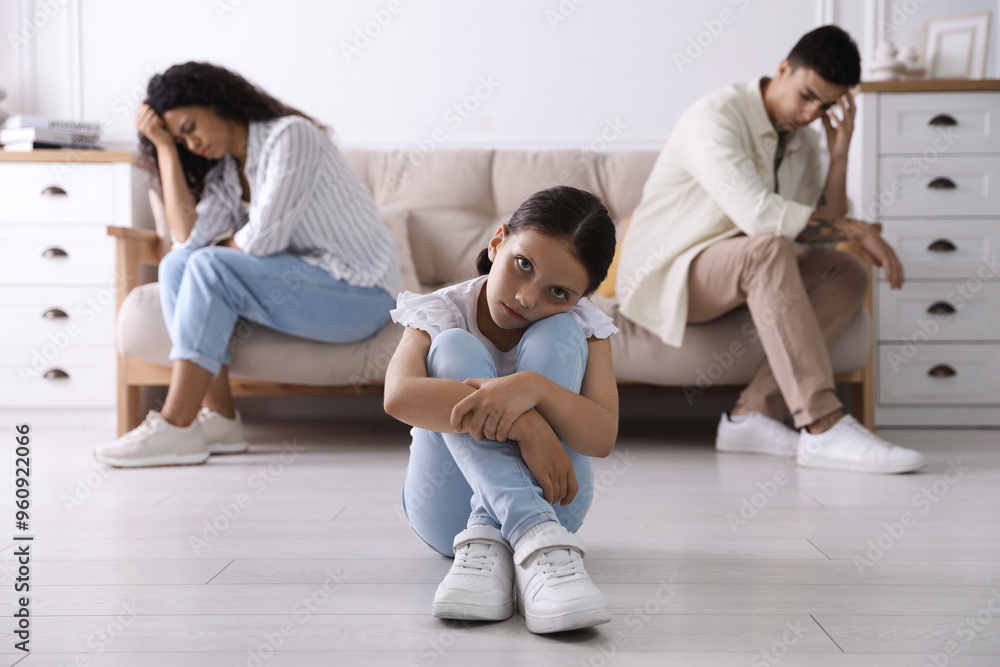 Divorce concept. Angry couple arguing at home, focus on their sad daughter Divorce concept. Angry couple arguing at home, focus on their sad daughter
