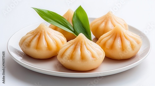 Delicious steamed dumplings with a delicate texture, arranged on a clean plate with fresh leaves for a delightful presentation.