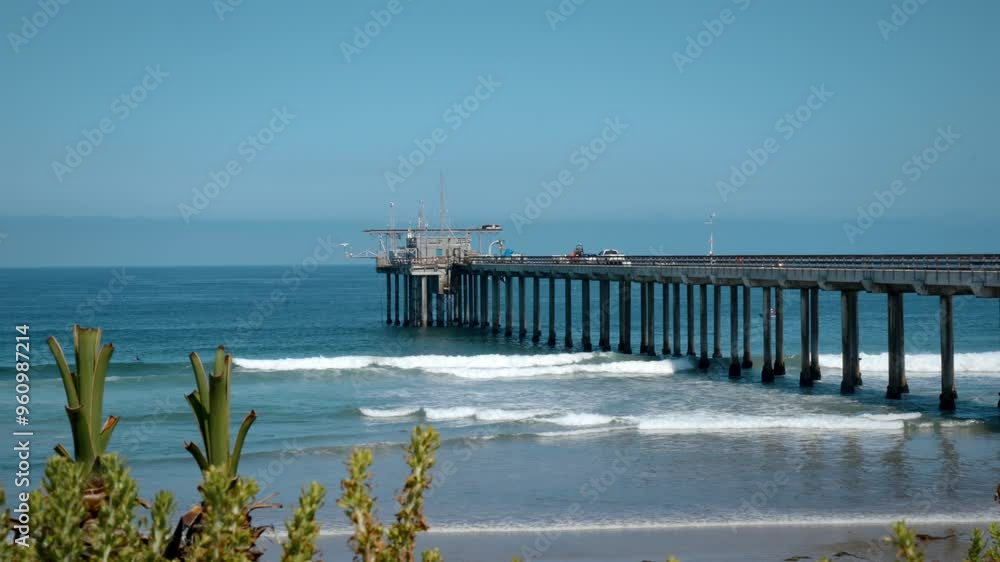 Aerial view of Scripps Pier near La Jolla Shores in San Diego California with blue sky and surfers in the Pacific Ocean Aerial view of Scripps Pier near La Jolla Shores in San Diego California with blue sky and surfers in the Pacific Ocean