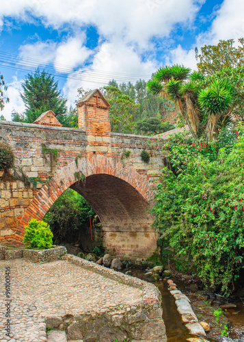 Historic Stone Bridge in Mongui, Boyaca, Colombia Surrounded by Lush Greenery photo