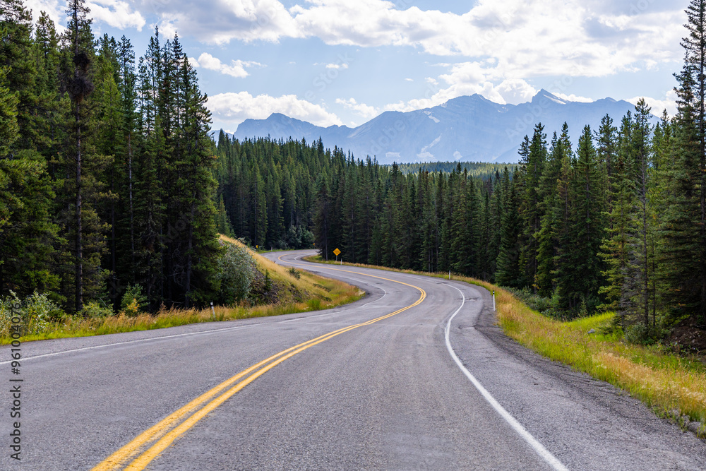 Scenic Curved Road Through Kananaskis Forest with Mountain Views in Alberta, Canada on a Sunny Day Scenic Curved Road Through Kananaskis Forest with Mountain Views in Alberta, Canada on a Sunny Day