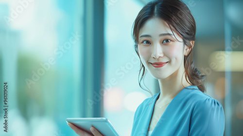 Smiling woman holding tablet in modern office setting, exuding confidence and professionalism.