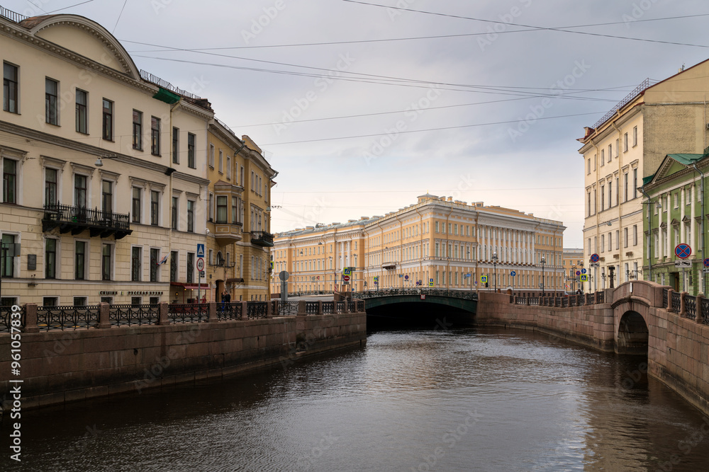 Moika River embankment and view of the east wing of the General Staff Building on a summer day with clouds, St. Petersburg, Russia Moika River embankment and view of the east wing of the General Staff Building on a summer day with clouds, St. Petersburg, Russia