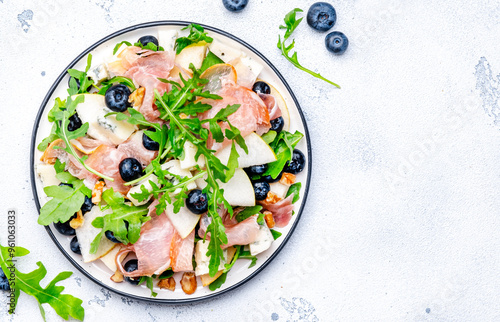 Photography Delicious salad with pears, blueberries, blue cheese, smoked ham, arugula and walnuts