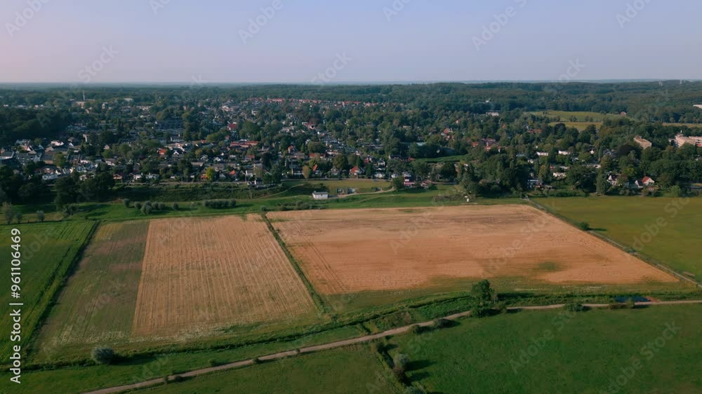Aerial view of Oosterbeek village in Gelderland next to a golden wheat field. Village, rebuilt after World War II, shows charming houses amidst greenery and farmland. Location: Oosterbeek, Netherlands Aerial view of Oosterbeek village in Gelderland next to a golden wheat field. Village, rebuilt after World War II, shows charming houses amidst greenery and farmland. Location: Oosterbeek, Netherlands