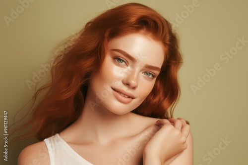 Wallpaper Mural Young woman with green eye patches on her face, isolated against a beige background. Close-up portrait of a ginger-haired girl wearing a T-shirt and looking away while smiling, applying a cosmetic gel Torontodigital.ca