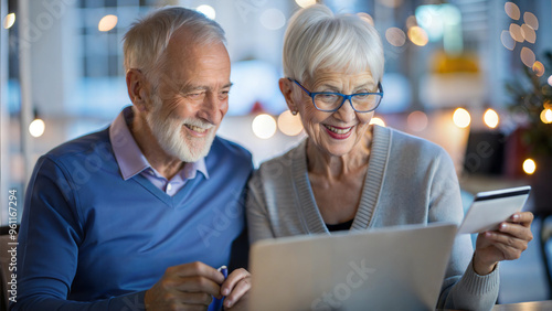 Senior couple using digital tablet and credit card at home in the evening