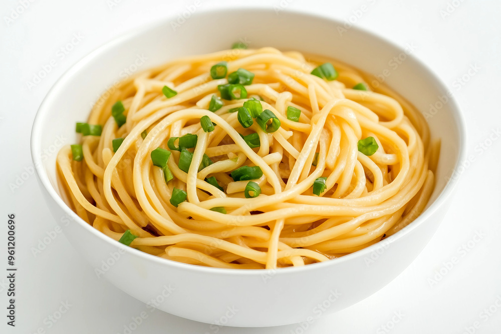 A bowl of pasta with green onions on top. The pasta is long and yellow. The bowl is white and sits on a white background A bowl of pasta with green onions on top. The pasta is long and yellow. The bowl is white and sits on a white background