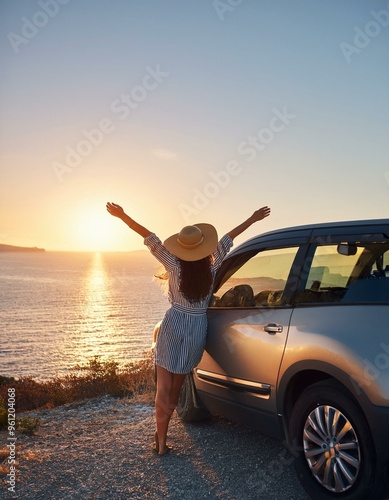 Mujer con los brazos abiertos en un acantilado viendo el atardecer al lado de un coche gris, de viaje, feliz, explorar, aventurera