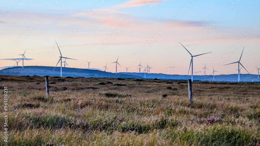 Wind turbines on wind farm under beautiful orange sunset sky at Galway, Ireland, green energy, environment, nature background